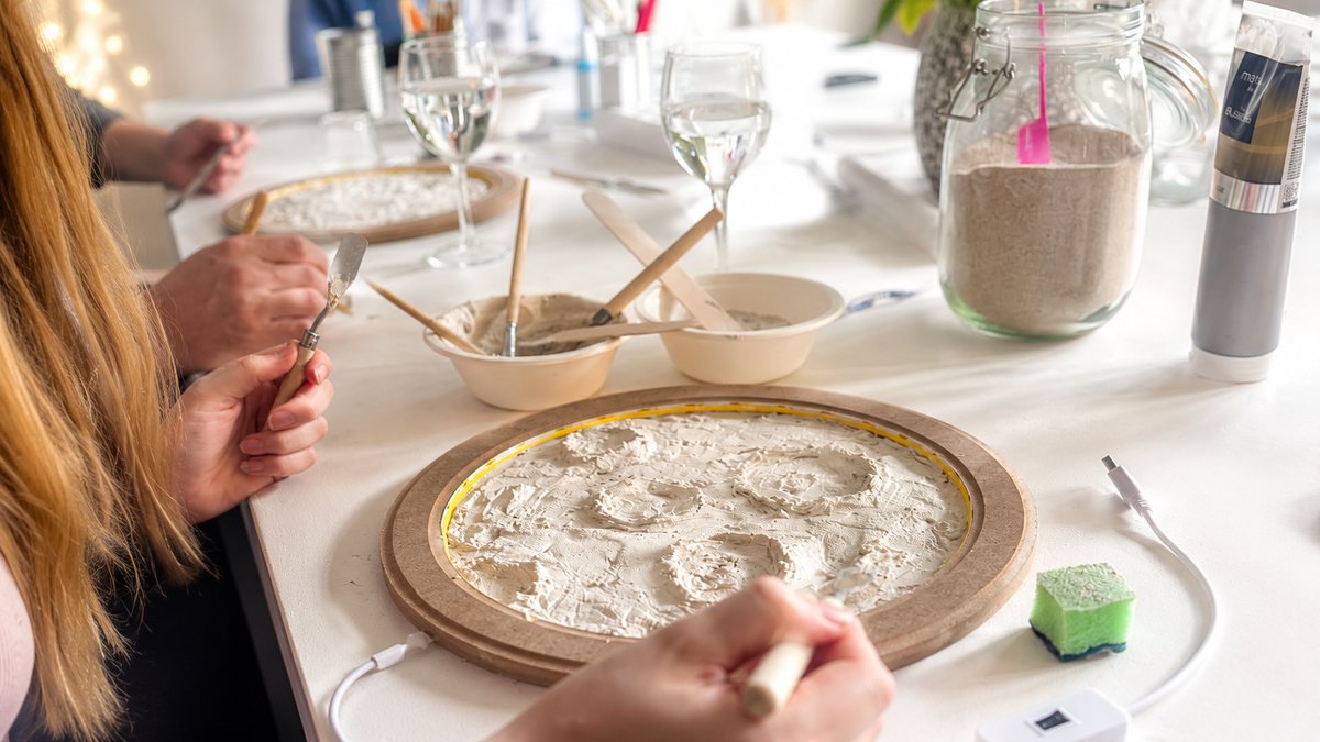 Teilnehmerin formt mit Spachtelmasse  die Kraterlandschaft im Workshop Mondlampe mit LED Beleuchtung im Atelier Einzigmacherei ind Norderstedt.